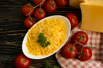 grated cheese, parsley on a wooden background