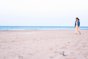 Joven turista disfrutando de un magnifico atardecer en una playa mediterránea. Concepto de moda y vacaciones