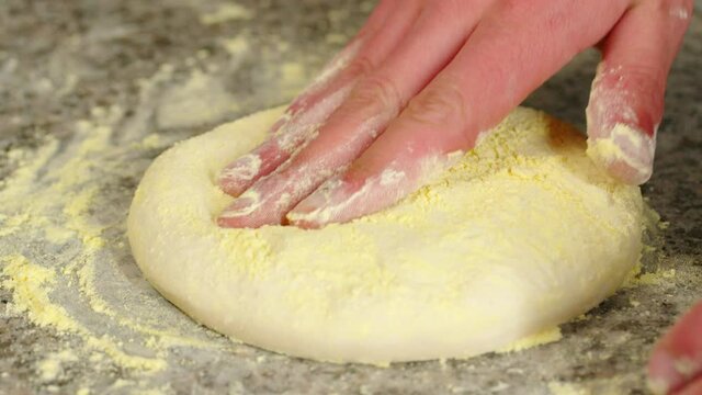 Senior professional italian restaurant chef working, shaping floured dough for pizza. Experienced cooker making pizza using traditional recipe.