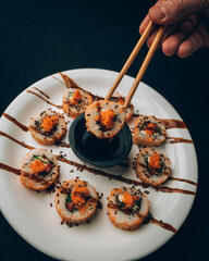 Plato de sushi con un boul de salsa de soja , con palillos chinos