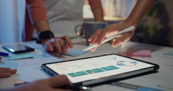 Close-up asia businesspeople meeting plan analysis statistics brainstorm and header of team hold tablet point graph chart and employee take note at home office night. Finance strategy success concept.