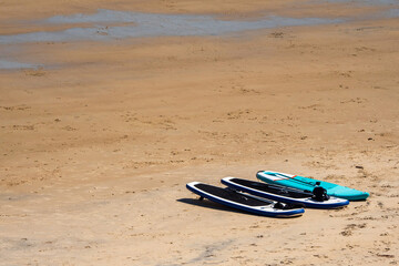 Three surfing boards on a yellow sand. Summer vacation and water sport concept.