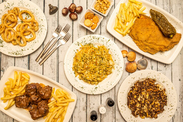 Set of typical Spanish dishes. Cachopo, scrambled eggs with blood sausage, stewed oxtail, battered squid and dorada cod.