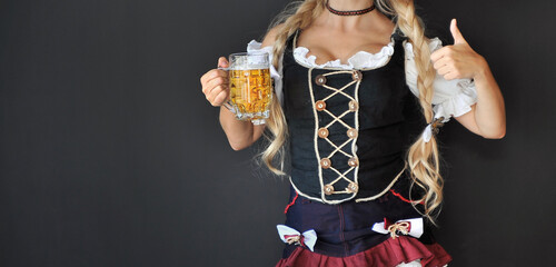 Beautiful blond woman with glass of beer. Oktoberfest 2021 concept.
