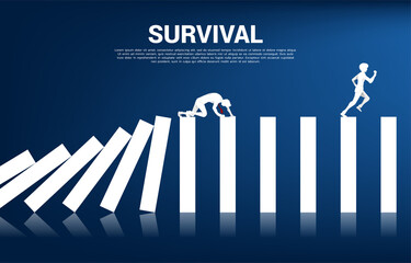 Silhouette of businessman crawl on domino collapse. Concept of business industry disrupt.