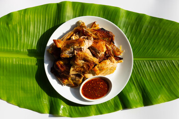 Grilled chicken, Thai style food on banana leaf on white background.