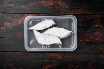 Frozen halibut pack , on old dark  wooden table background, top view flat lay, with copy space for...