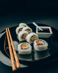 Plato de sushi , comida japonesa, con salsa de soja y palitos chinos.
