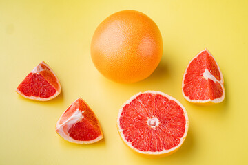 Juicy pink grapefruit cut , on yellow textured summer background