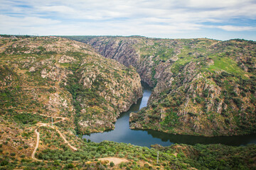 Fototapeta na wymiar Scenic view from the top of the cliffs in the Natural Park of Douro - Portugal. Sightseeing place of Fraga do Puio in the top of the mountains with the Douro river on the bottom