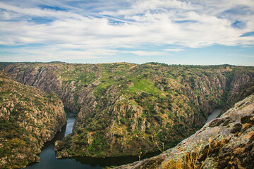 Fototapeta na wymiar Scenic view from the top of the cliffs in the Natural Park of Douro - Portugal. Sightseeing place of Fraga do Puio in the top of the mountains with the Douro river on the bottom