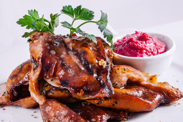 Roasted pork ears with fresh horseradish sauce on white plate