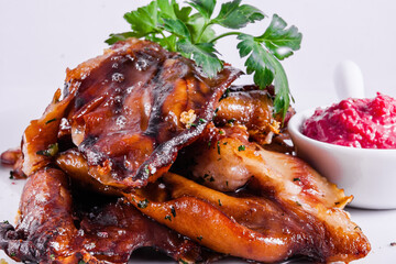 Roasted pork ears with fresh horseradish sauce on white plate