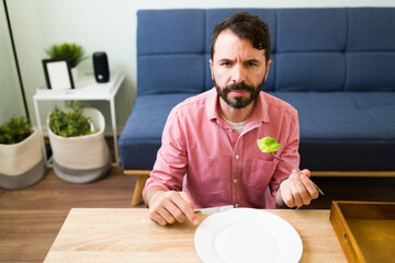 Latin man making eye contact while eating very little