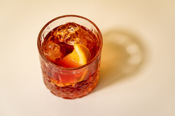 Top view of Negroni cocktail with orange wedge on white surface
