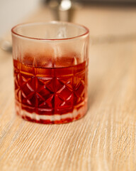 Front view of negroni cocktail in a glass tumbler on a wooden surface