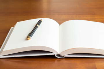 テーブルに置かれたまっさらな本とボールペンのクローズアップ