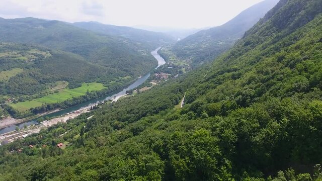 A drone flight over a most scenic landscape view with huge mountains and a river and valley.