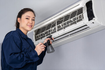 female technician service cleaning air conditioner indoors