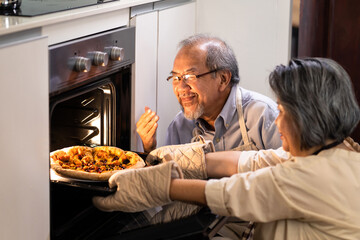 Asian Senior older couple grandparents making pizza in kitchen at home