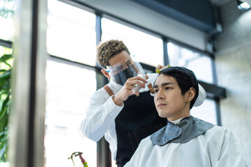 Asian hairdresser barber wear mask, cut hair of attractive man in shop