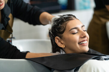 Caucasian young woman get hair washed by Hairdresser stylist in salon.