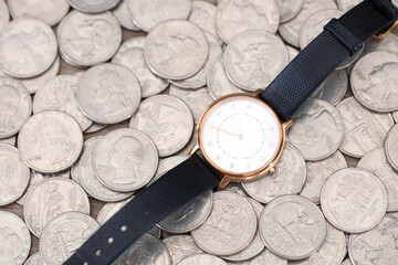 Watch on a background of spread of dollar coins