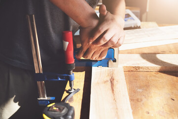 Entrepreneur Woodwork holding a Tacker to assemble the wood pieces as the customer ordered.