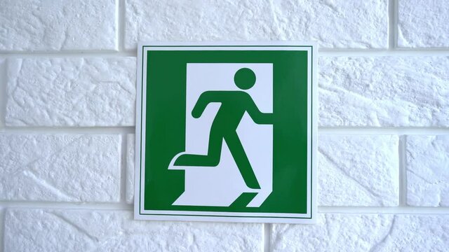 Exit emergency sign in 4K slow motion. An exit sign hangs on a wall. 4k stock footage.