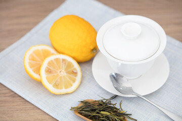 Gaiwan tea and yellow lemon on the table