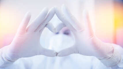 Nurse coronavirus with medical mask and blue glove hands shows symbol of love heart. Concept safety...