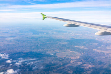 Fototapeta premium View from the airplane window at a beautiful blue sunrise and the airplane wing in clear sky.