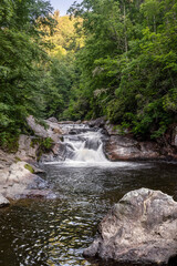 Fototapeta premium A popular swimming hole, Bust Your Butt Falls is a small waterfall on the Cullasaja River in Nantahala National Forest near the town of Highlands in the beautiful mountains of western North Carolina.