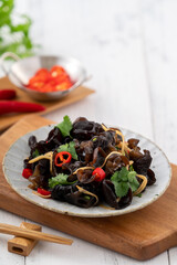 Boiled small black fungus cold dish on white table background.