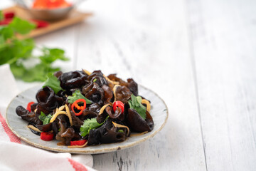 Boiled small black fungus cold dish on white table background.