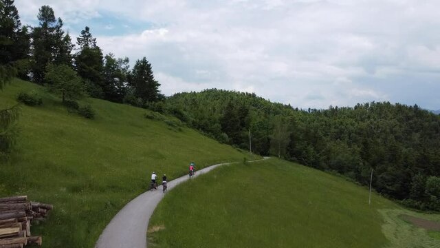 Family at cycling trip in nature. Group of people on bikes. Aerial video.