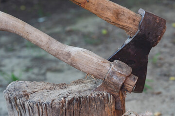big and small ax stuck in a tree stump