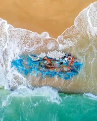 Foto auf Acrylglas Broken boat and fishing nets washed up on a beach fish shape water sand debris waste plastic wood environmental global warming concept © Huw Penson