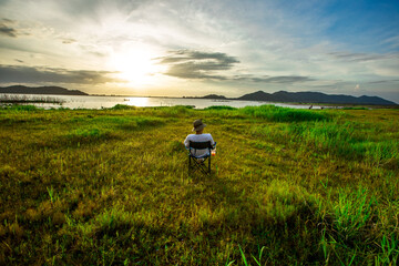 Natural background of green fields along a large reservoir and surrounded by many trees, the beauty of the ecosystem