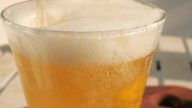 Top of beer glass in closeup displaying all the tiny bubbles and bright white foam. The slow motion captures the foam sliding down the side of the glass.
Beer and other beverages concept footage.