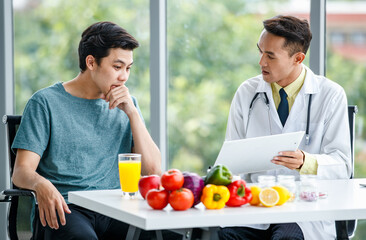 Friendly Asian nutritionist showing table to patient