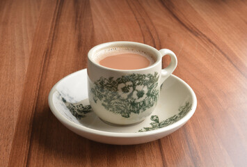 hot milk tea local Indian traditional teh Tarik in small cup on wood table hot beverage menu
