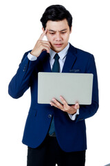 Young attractive asian business man wearing navy blue suit with white shirt and necktie holding and using his laptop with one hand on his head thinking on white background isolated