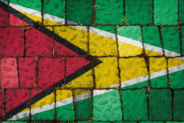 National flag of Guyana on stone  wall background. Flag  banner on  stone texture background.