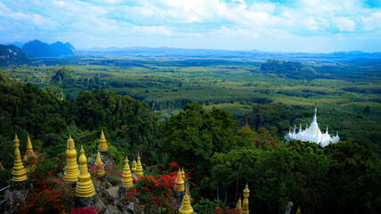Panorama view, white pagoda and the little golden pagodas standing among  the green woods...