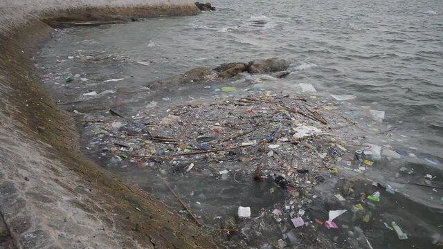 garbage on the baech Beach pollution. Plastic bottles and other trash on sea beach