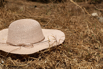 woman hat on a haystack. Beige Women's beach cap. colorful Wicker farmer hat in the background of hay. yellow hat. Summer travel concept, vacation at sea, farm. Banner. copy space.