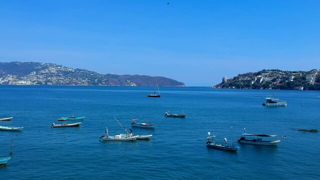 Vista a&eacute;rea de la Bah&iacute;a de Acapulco con lanchas y cielo azul. Panor&aacute;mica a&eacute;rea de la Bah&iacute;a de Acapulco y sus lanchas. Lanchas navegando en la Bah&iacute;a de Acapulco.