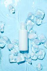 Bottle of cosmetic product and ice cubes in water on color background