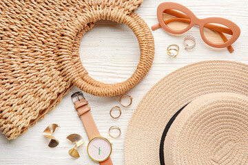 Set of female accessories with stylish hat on light wooden background